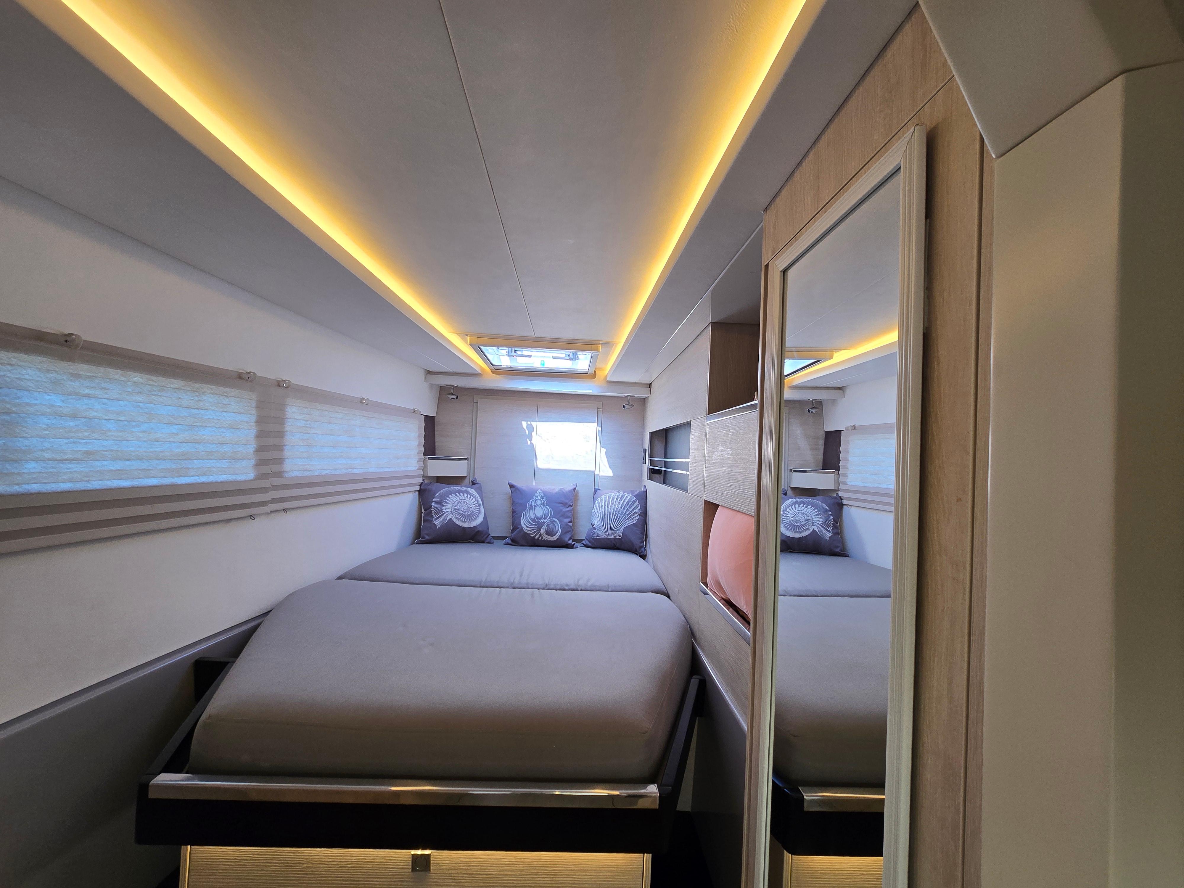 Cabin with gray bed covering and nautical pillows
