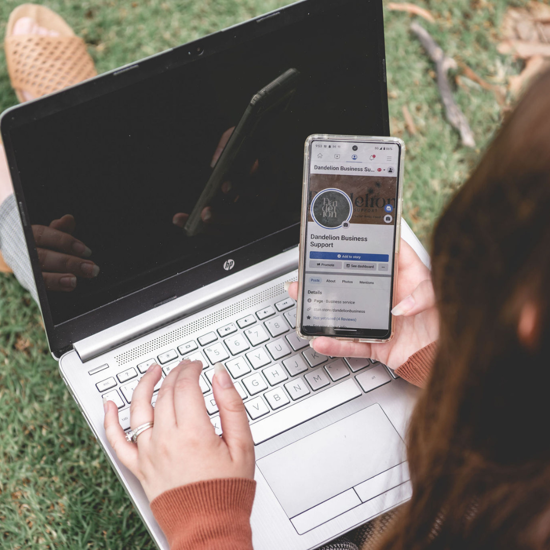 Dandelion Business Support client reviewing social media on phone and laptop