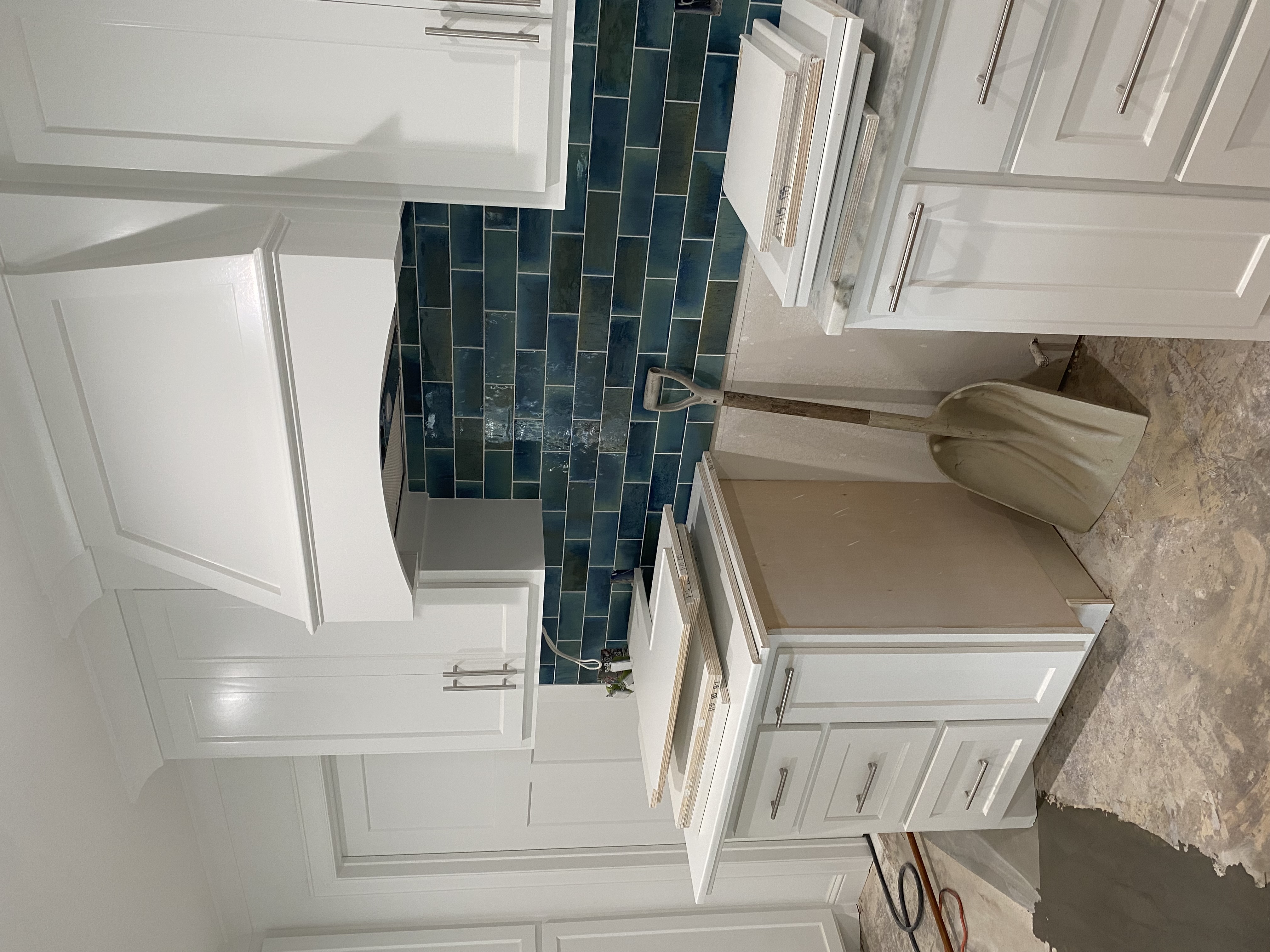 JR Works white shaker cabinets with deep emerald subway tile backsplash installation
