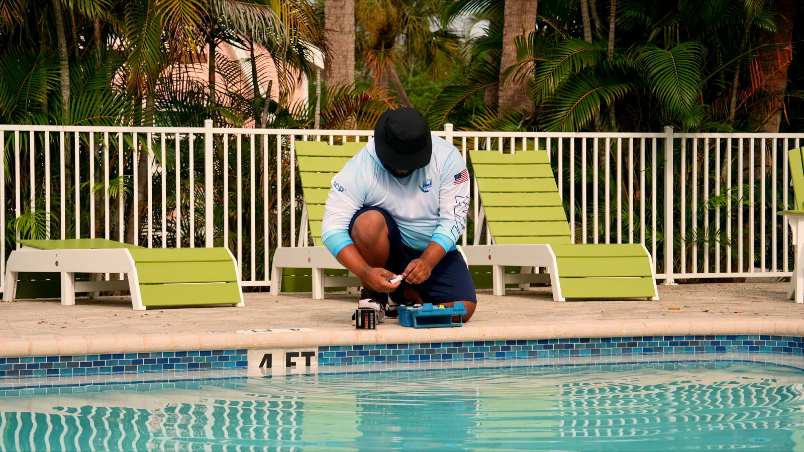 ICM pool technician testing water chemistry with test kit at poolside