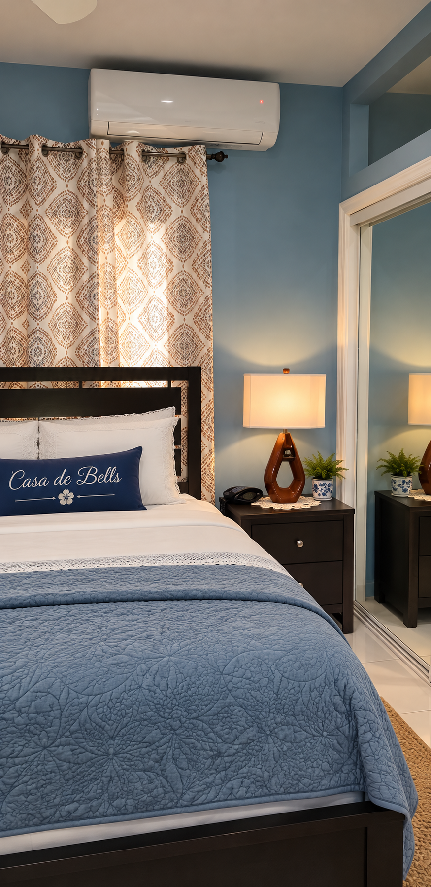 Bedroom suite with plush bed, custom Casa de Bells pillow, and quiet split-unit AC