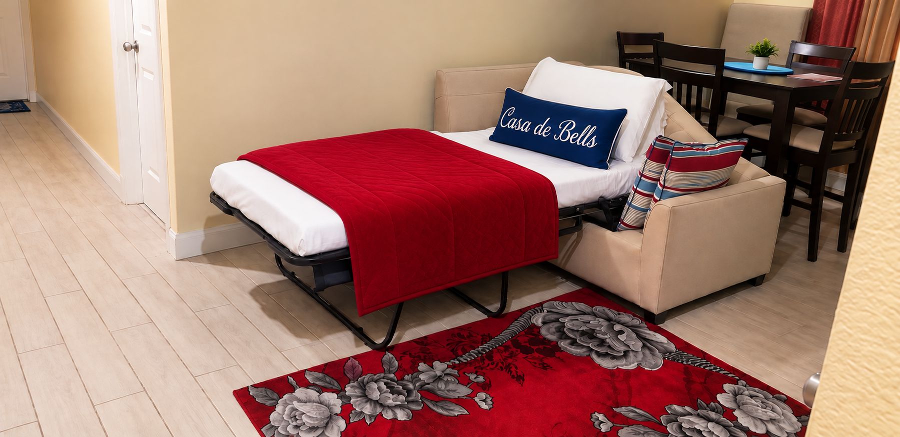 Convertible sofa bed made up with Casa de Bells pillow and red throw