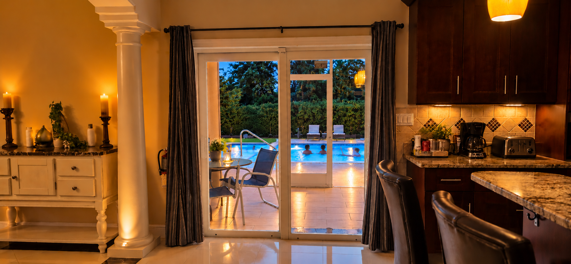 View from the dining area through patio doors to the illuminated pool