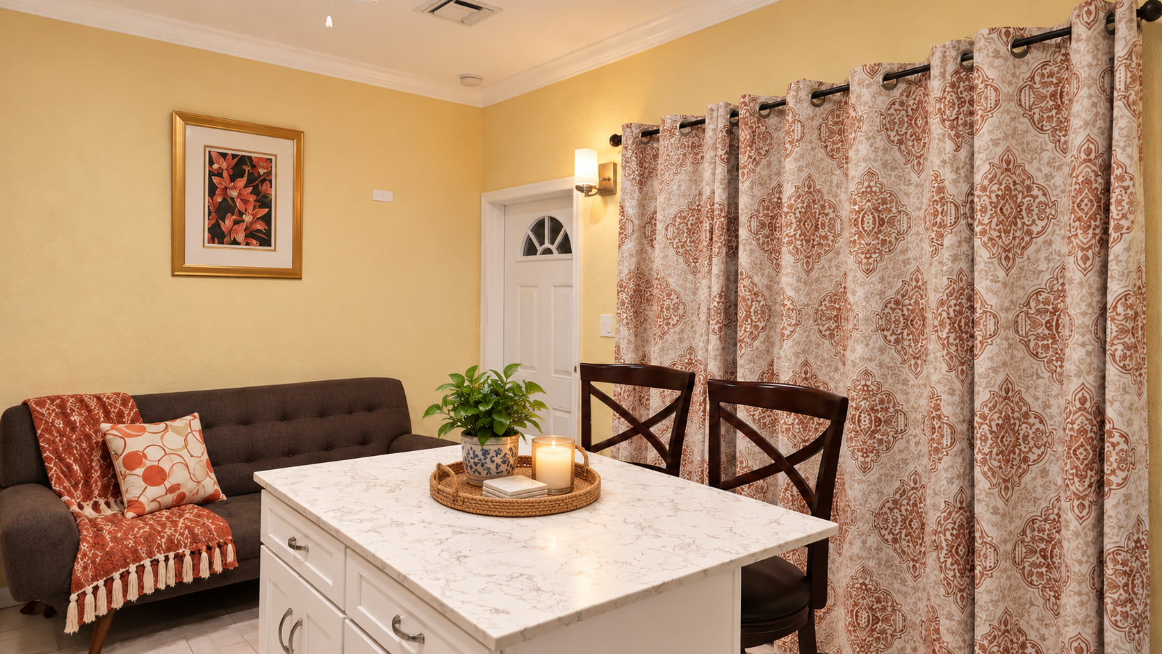 Kitchen island breakfast bar with marble countertop and seating adjacent to the living room