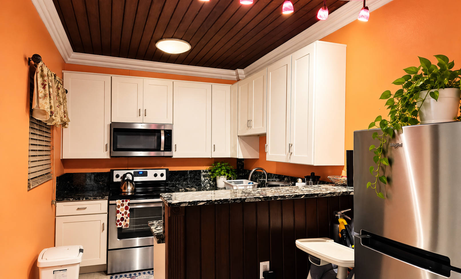 Full kitchen with white cabinetry, stainless steel appliances, and breakfast counter