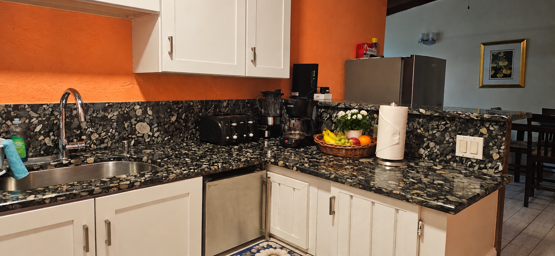 Fully equipped kitchen with mosaic stone countertops and appliances
