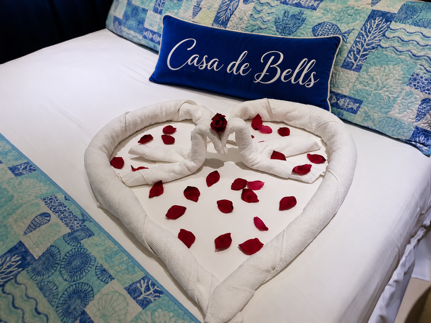 Romantic swan towel heart and rose petal welcome on the bed