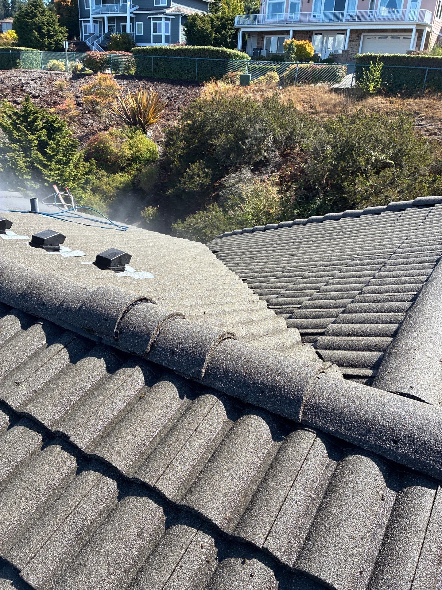 Concrete tile roof fully cleared of moss and grime, sharp ridges and pristine surface