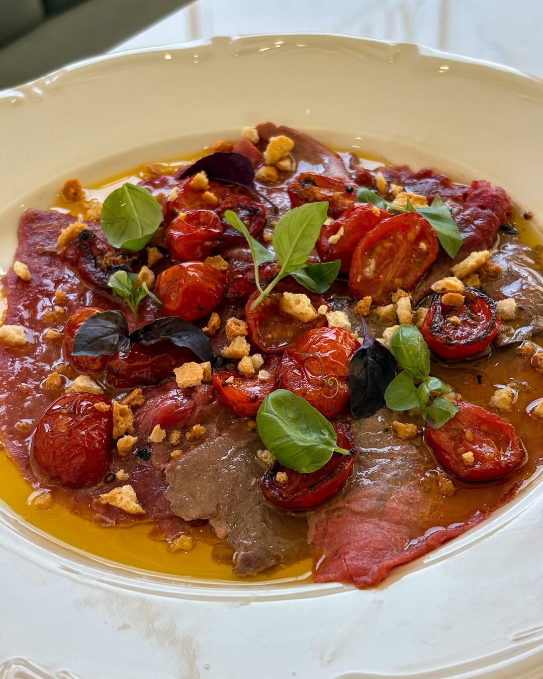 Piatto del menù di Armonì con pomodorini e basilico fresco
