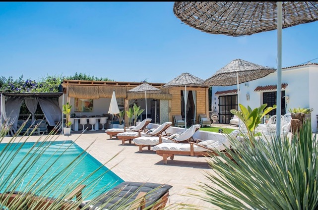 Zonneterras en rieten parasols bij het zwembad van Villa Fahala