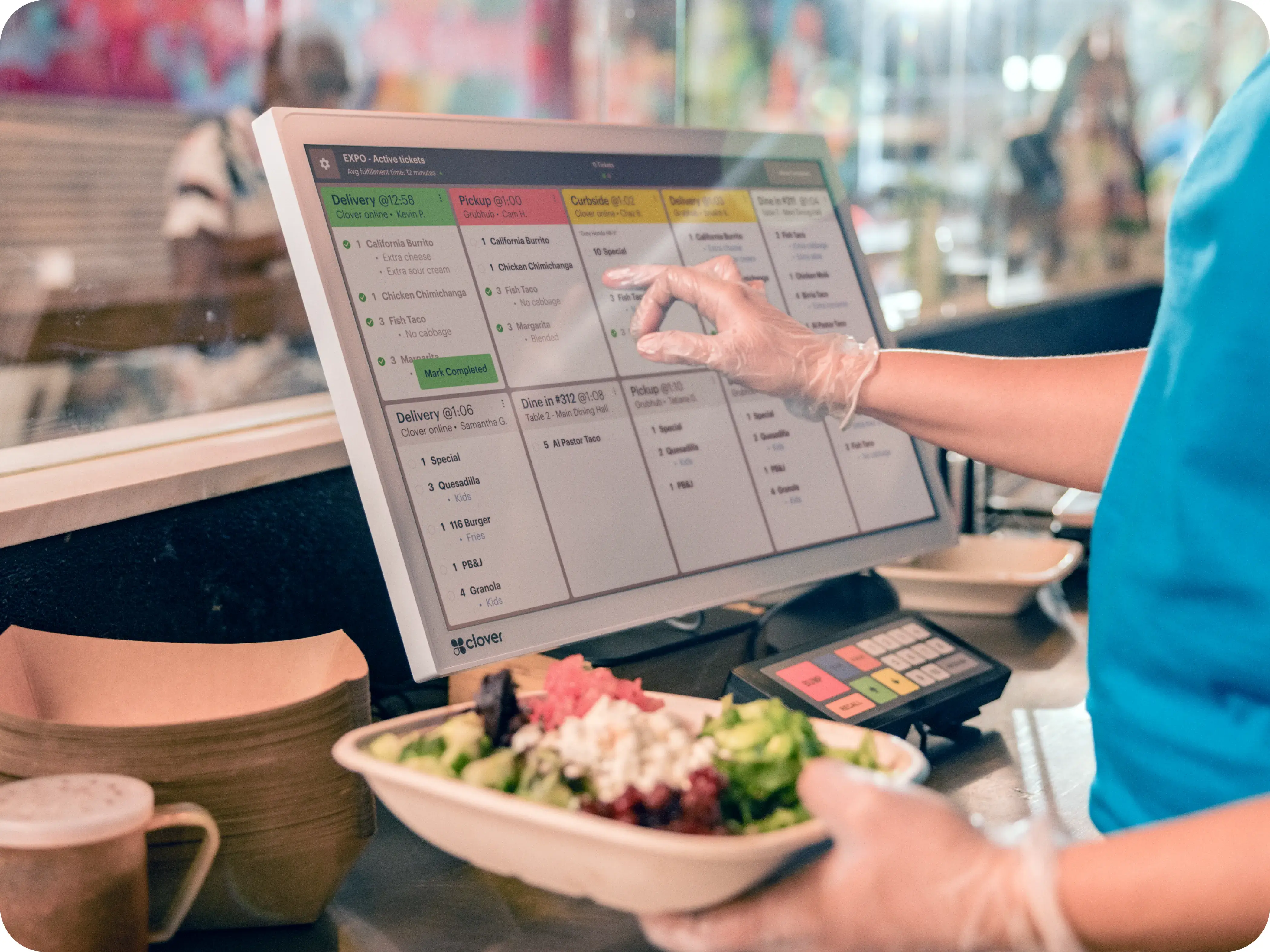 Kitchen staff using Clover Kitchen Display System to fulfill active restaurant orders