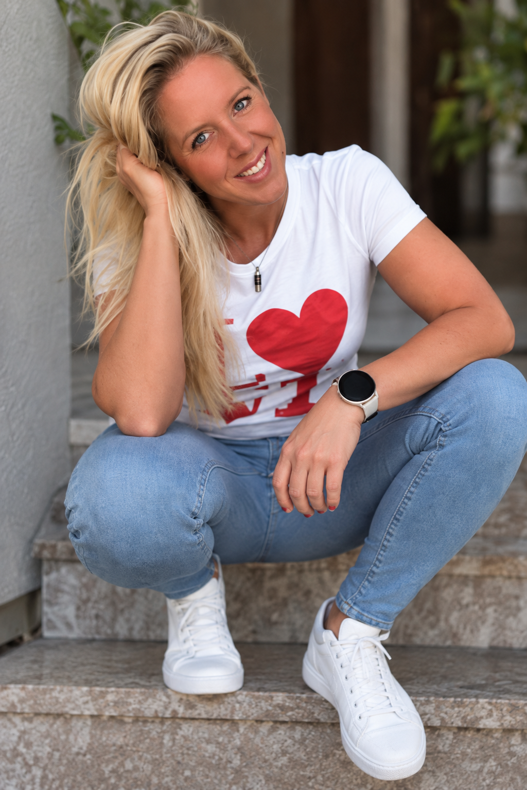 Jennifer Beck im weißen Shirt auf der Treppe