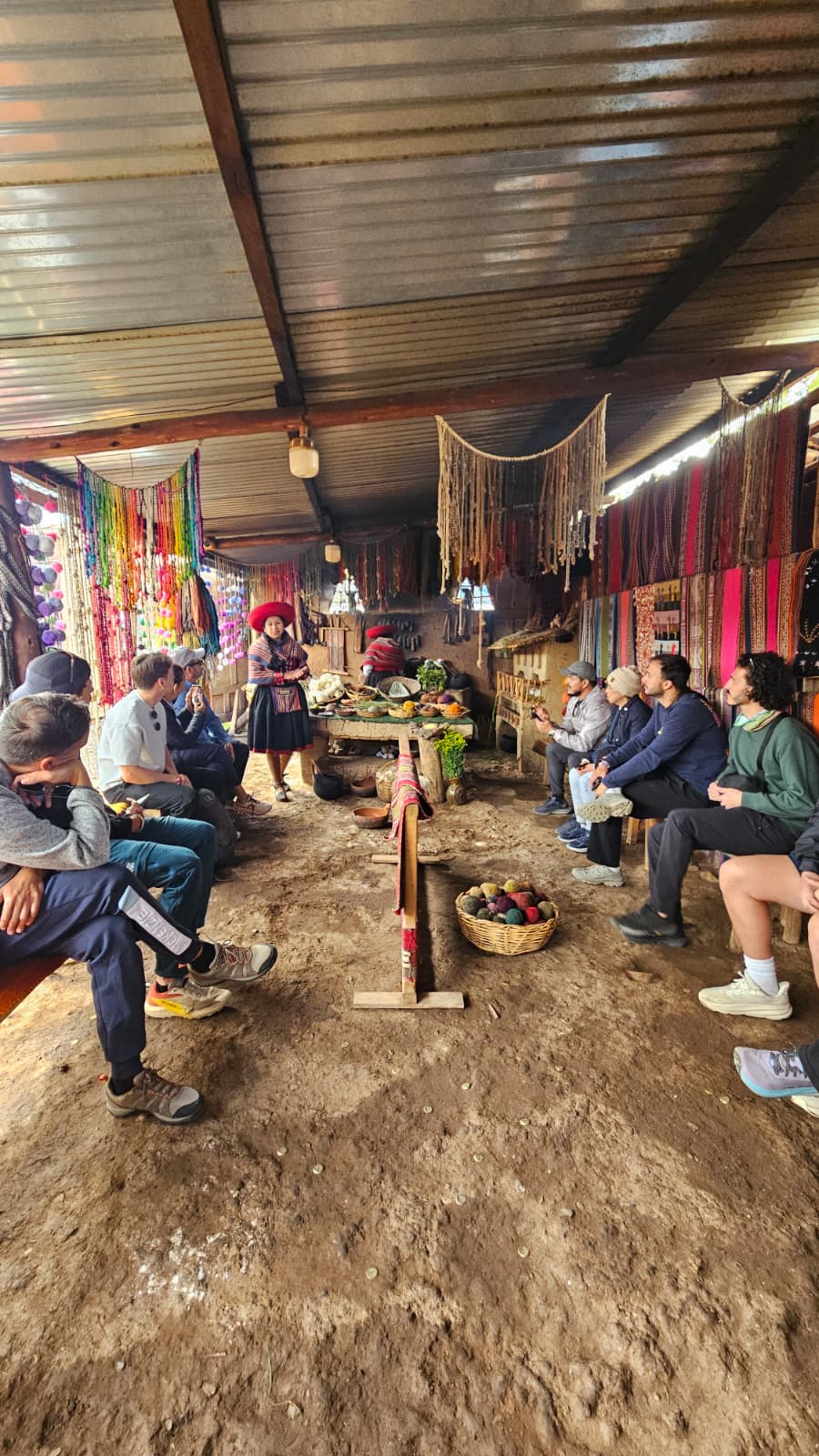 Grupo de viajeros de Viajes y Turismo Amazonas en una experiencia cultural con una mujer y artesana local en Perú