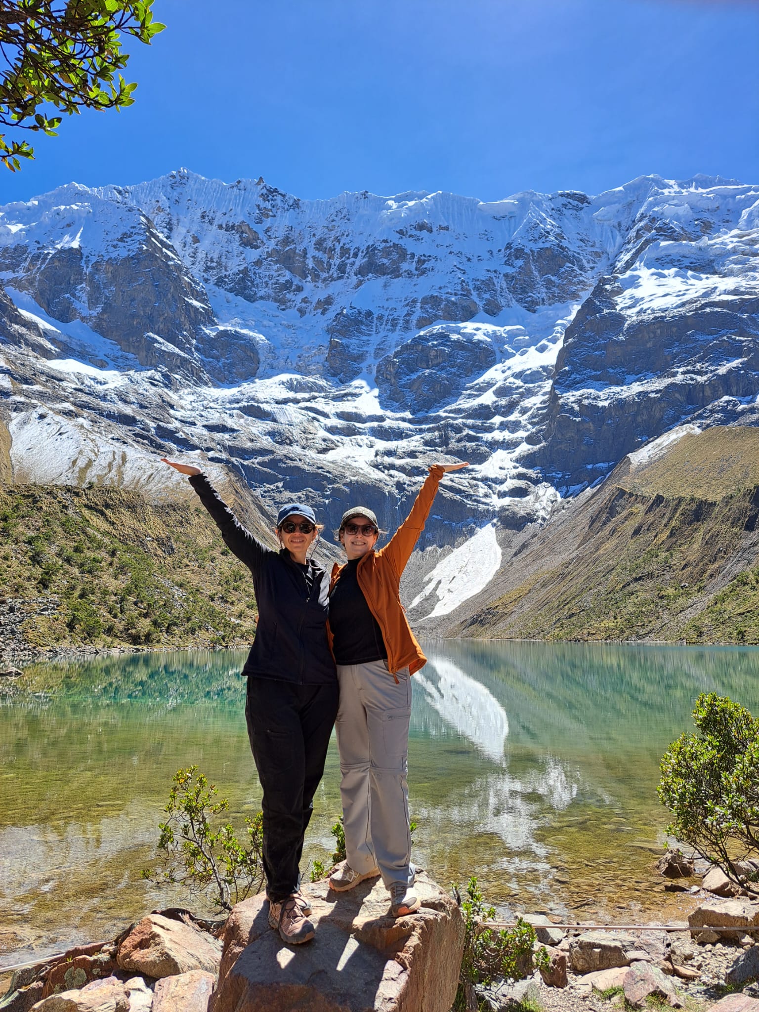 Viajeras en la Laguna Humantay con las cumbres nevadas de fondo