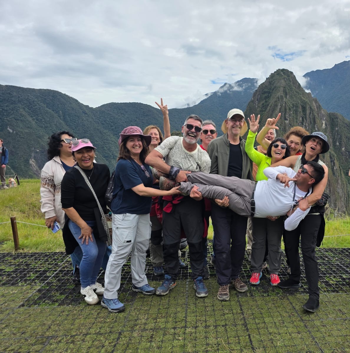 Grupo alegre de viajeros con Machu Picchu y las montañas de fondo
