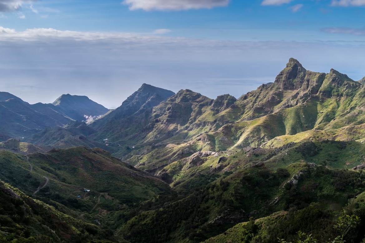 Paisaje agreste del macizo de Anaga con vegetación verde de laurisilva y crestas volcánicas cayendo hacia el mar