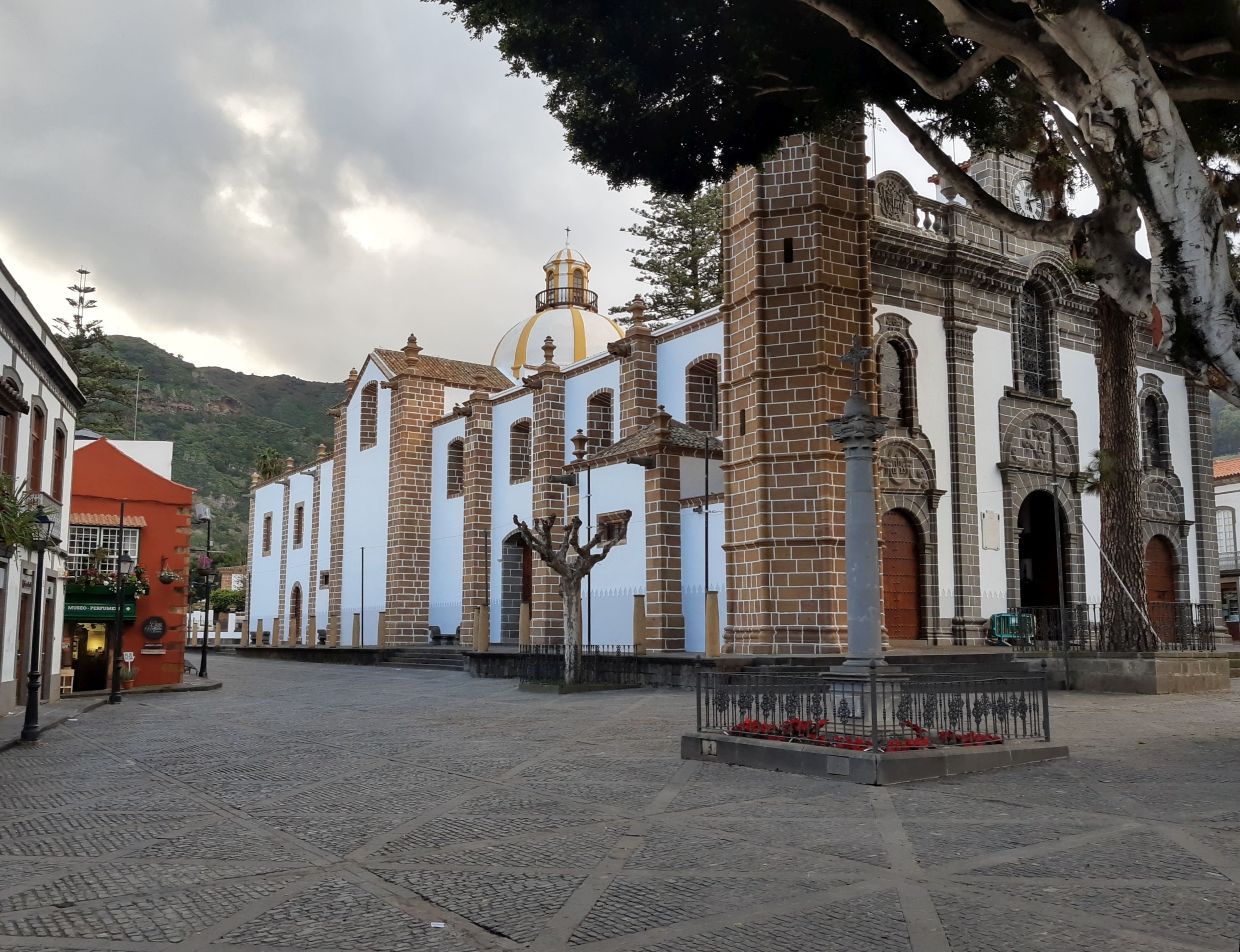 Basílica de Nuestra Señora del Pino con su fachada de cantería, torre campanario y la plaza empedrada en Teror