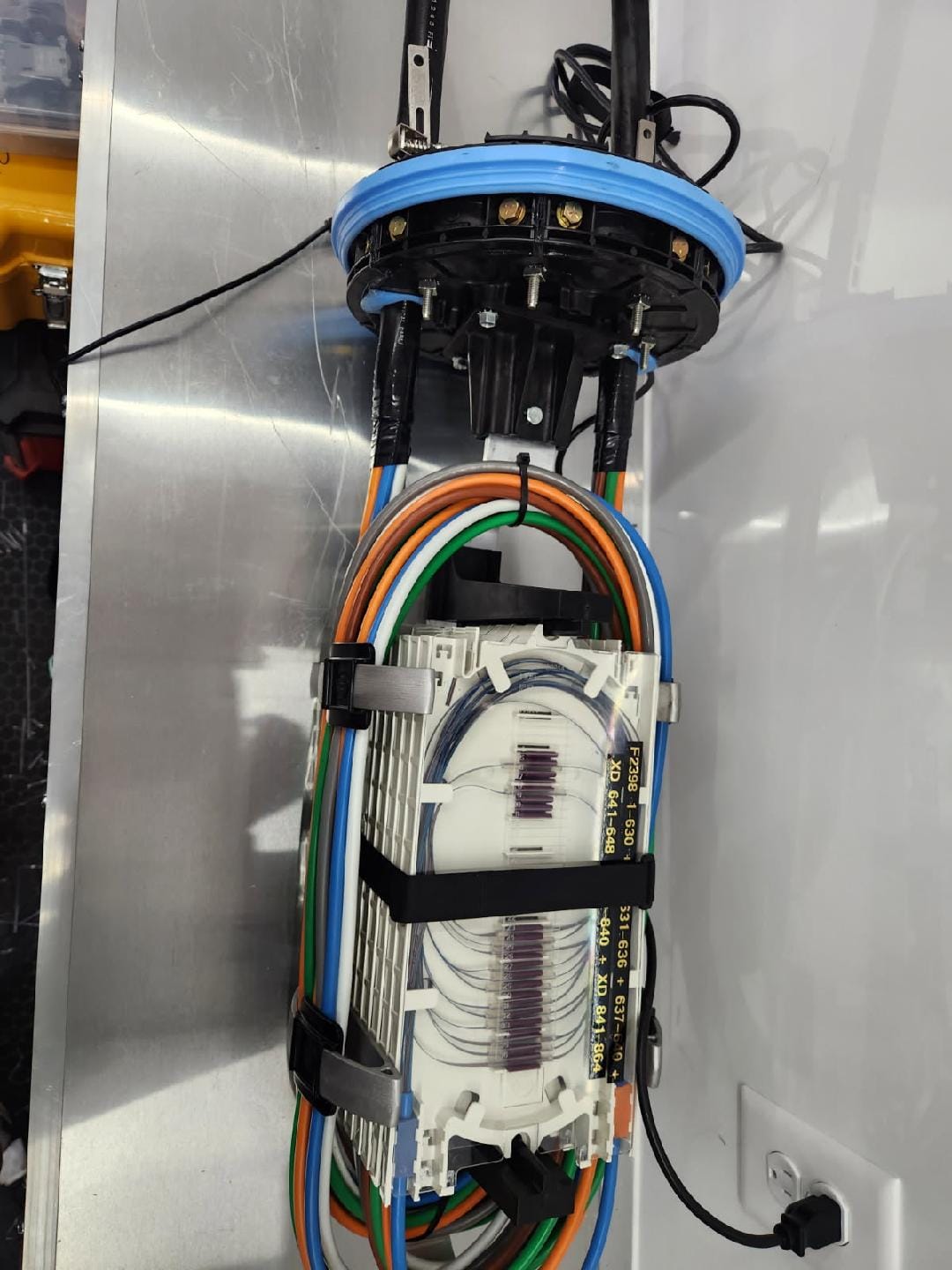 FOSC dome enclosure assembly mounted on stainless steel field table with multi-tray fiber organizer and color-coded buffer tubes