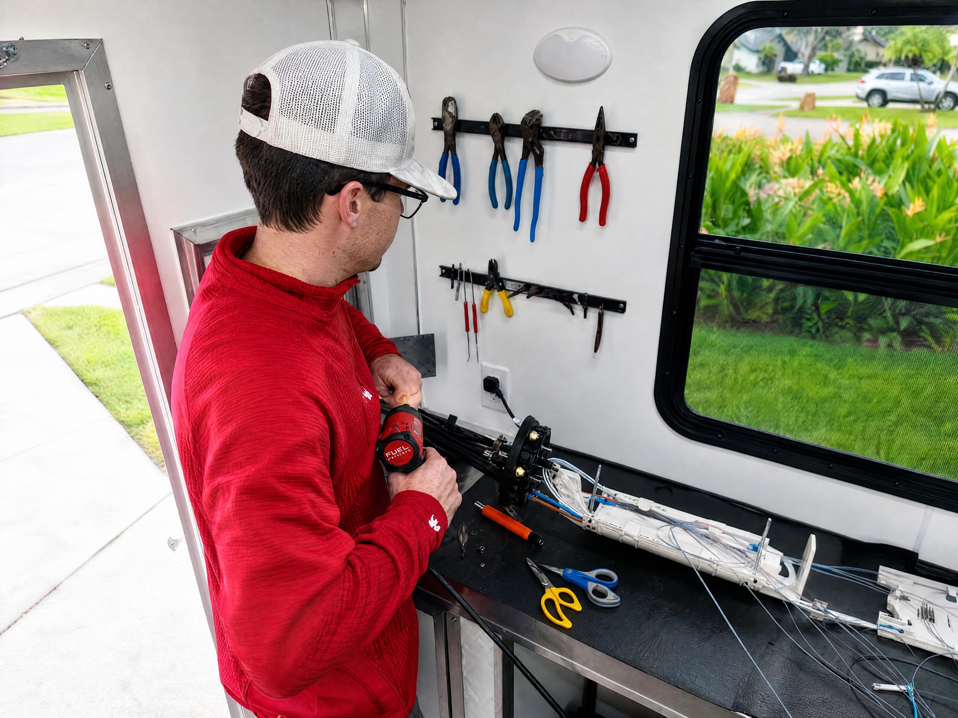 FAFO technician working on fiber optic splice enclosure inside mobile field lab