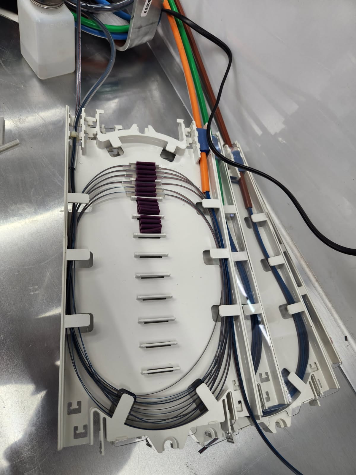 Multi-tray fiber organizer stack showing individual tray fiber routing and protective transparent covers
