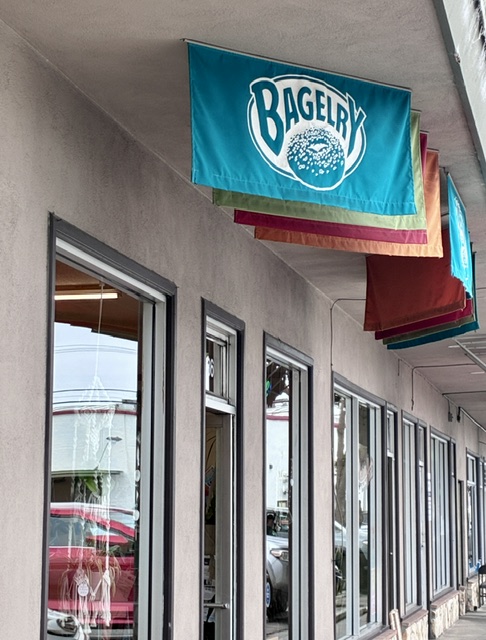 The Bagelry flags and storefront along Seabright Plaza