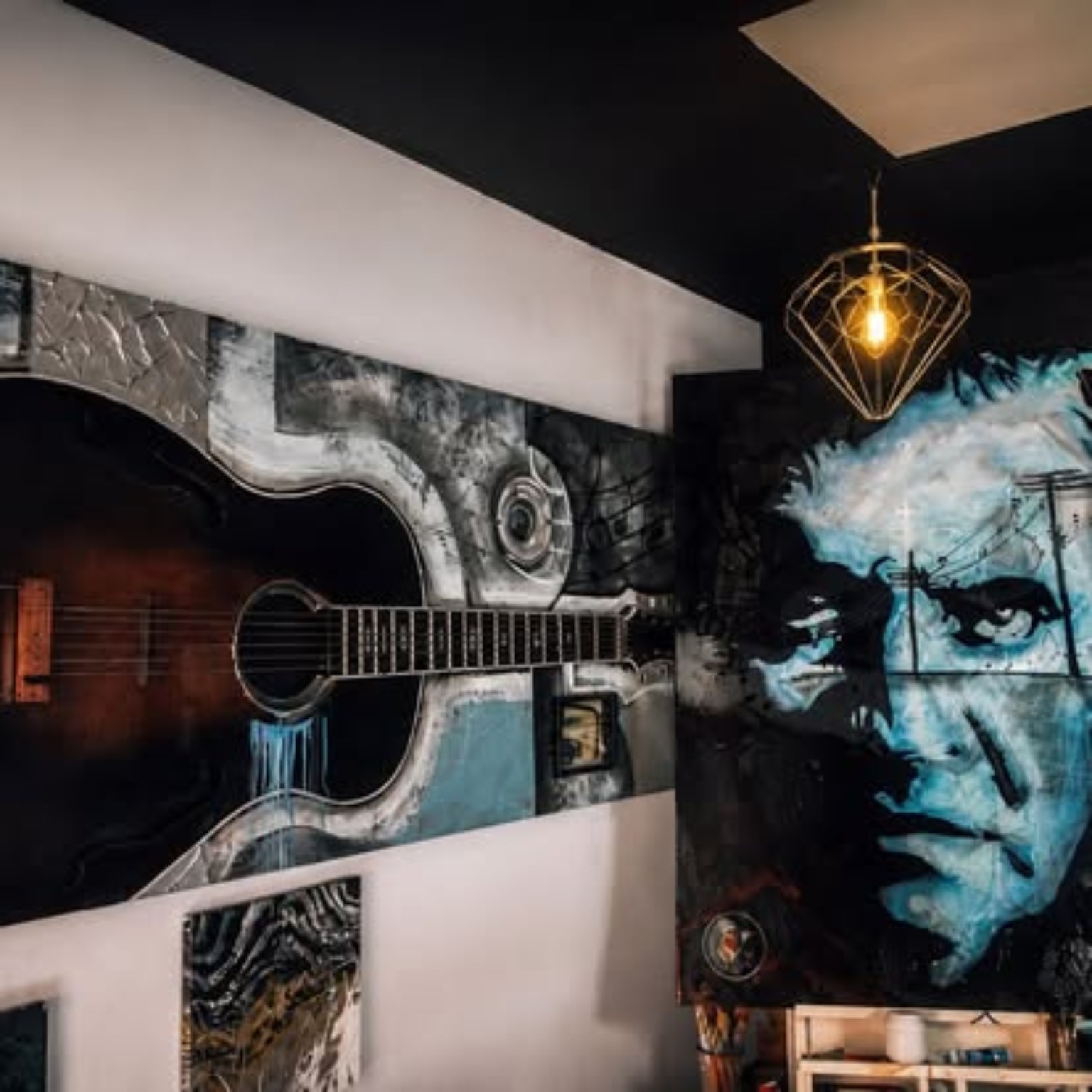 Full room view of acoustic guitar and blue portrait wall art installation with ambient lighting