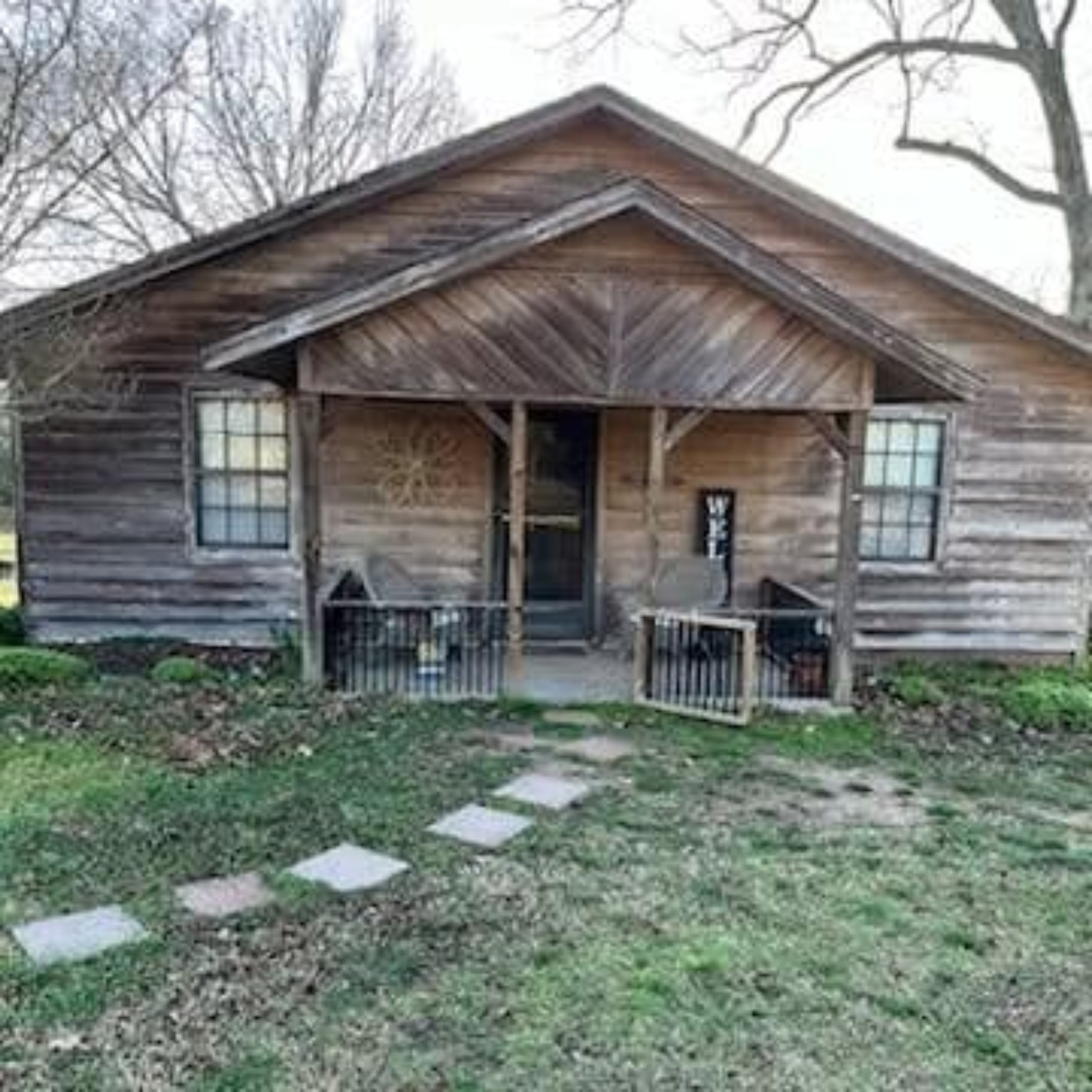 Weathered wood house exterior with porch before restoration and staining