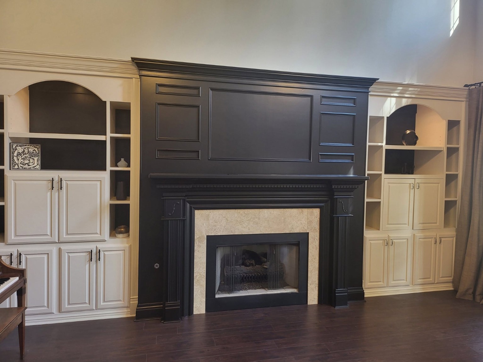 Completed dramatic black fireplace mantel and surround with contrasting white built-in cabinetry