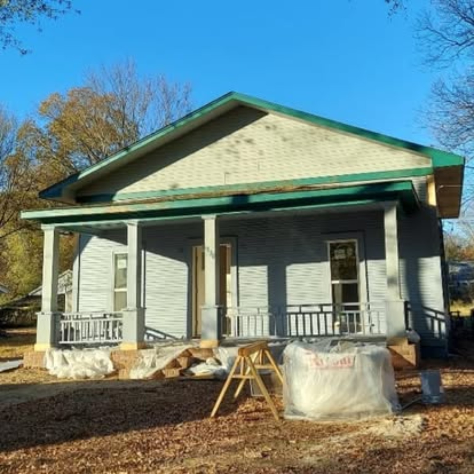 Front porch home before painting with weathered siding and faded green trim