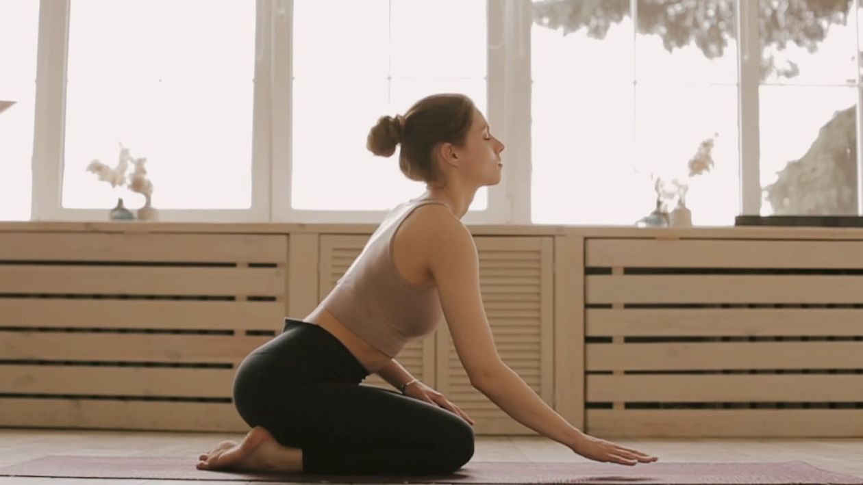 A bright sophisticated morning room where a woman performs a gentle morning mobility sequence