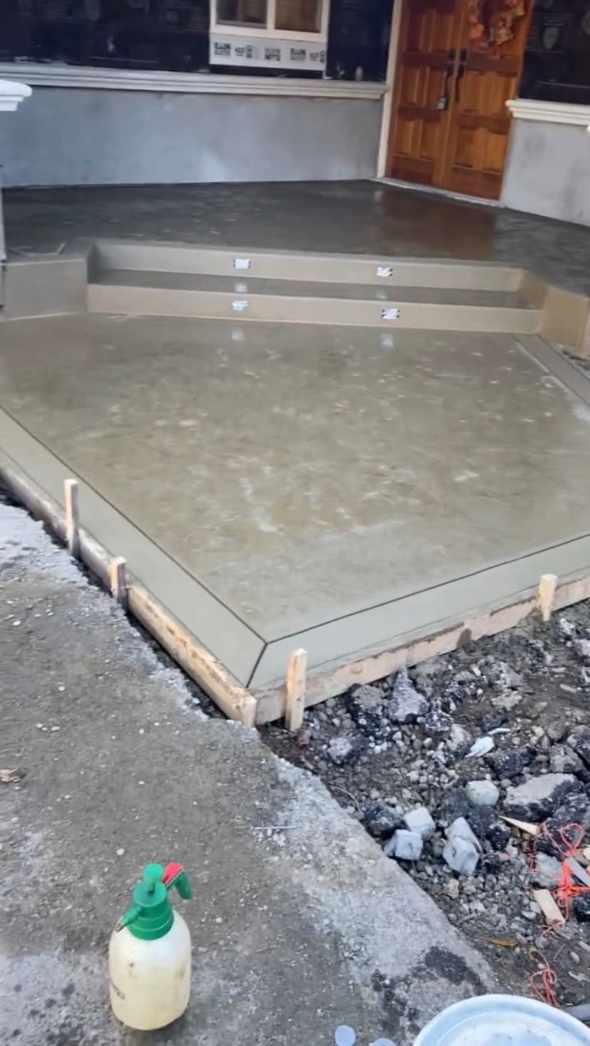 Custom concrete front entryway with integrated steps, picture frame border, and smooth cured finish