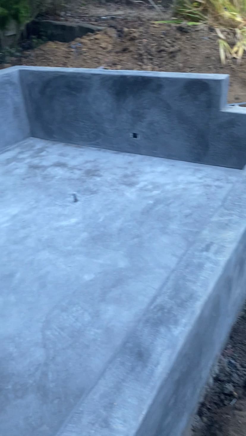 Solid concrete foundation slab with integrated retaining perimeter walls and smooth troweled finish