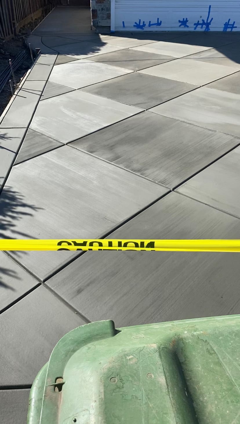 Custom geometric diamond scored concrete driveway with precision borders and smooth finish