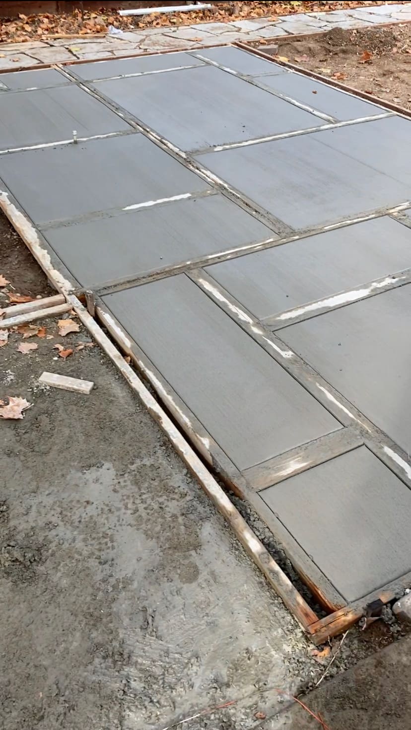 Precision framed concrete pad and walkway with picture frame troweled edge borders and broom finish