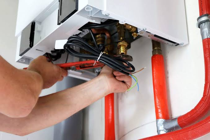Gas boiler technician servicing Ideal boiler components
