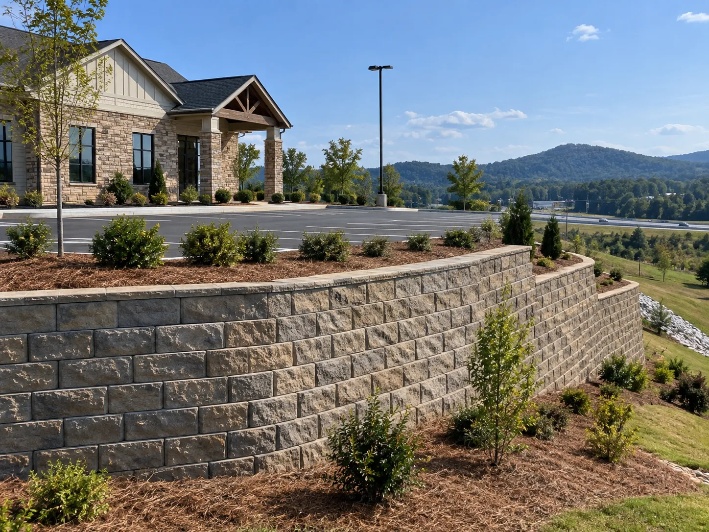Commercial retaining wall holding grade along a commercial building parking lot and hillside