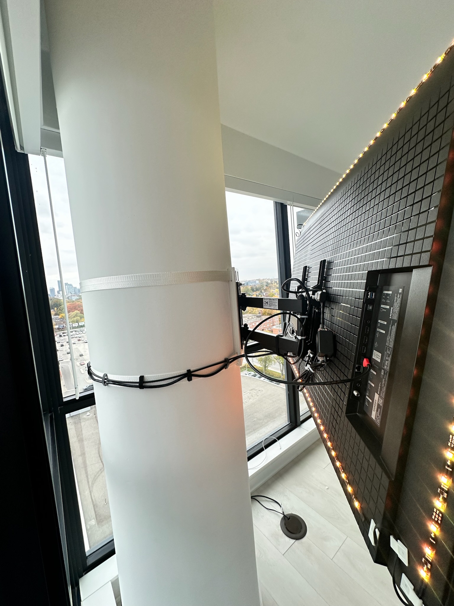 Side profile detail of wraparound industrial strap pillar mount with articulating arm