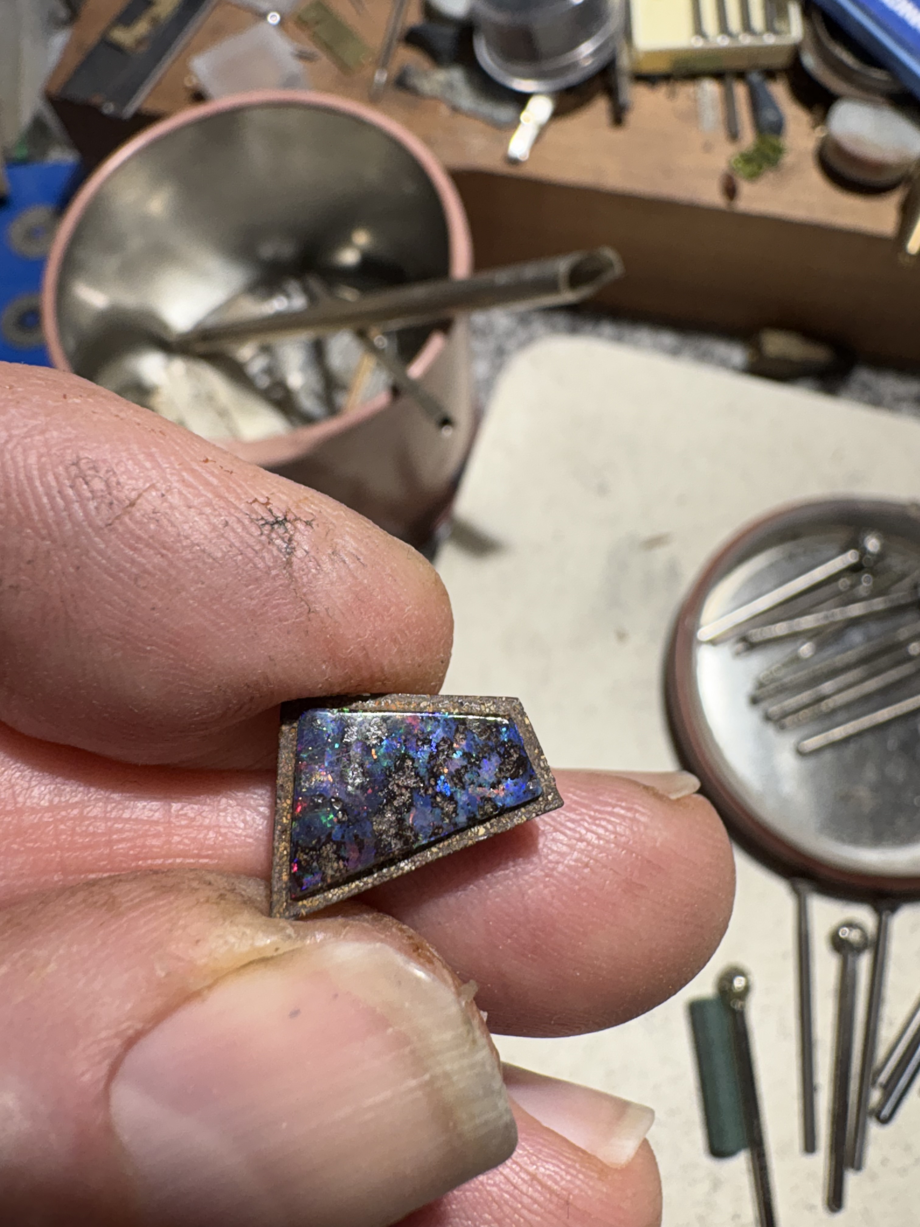 Gary Upton inspecting the recut boulder opal with shoulder at the bench