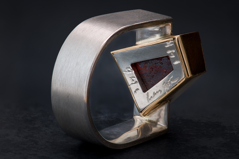 Underside of the boulder opal ring showing the open-center plug and maker's mark