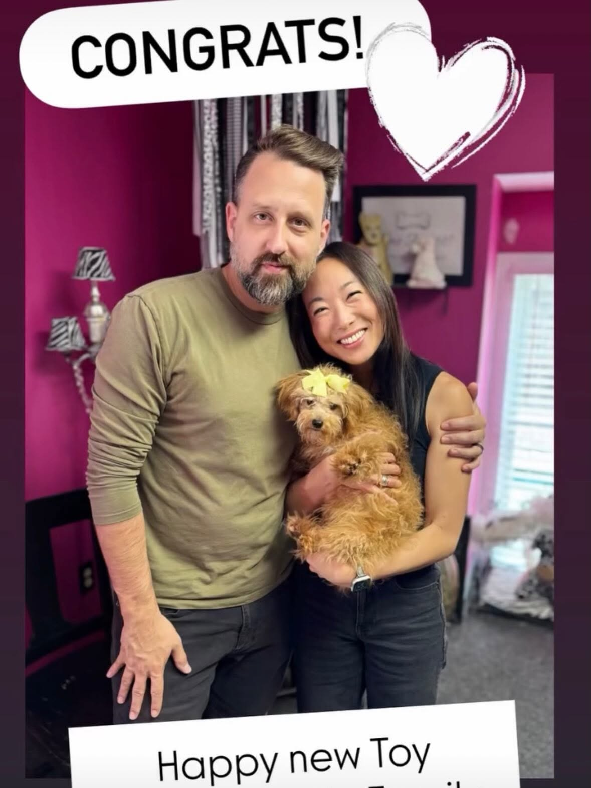 Smiling couple hugging their new puppy at pickup