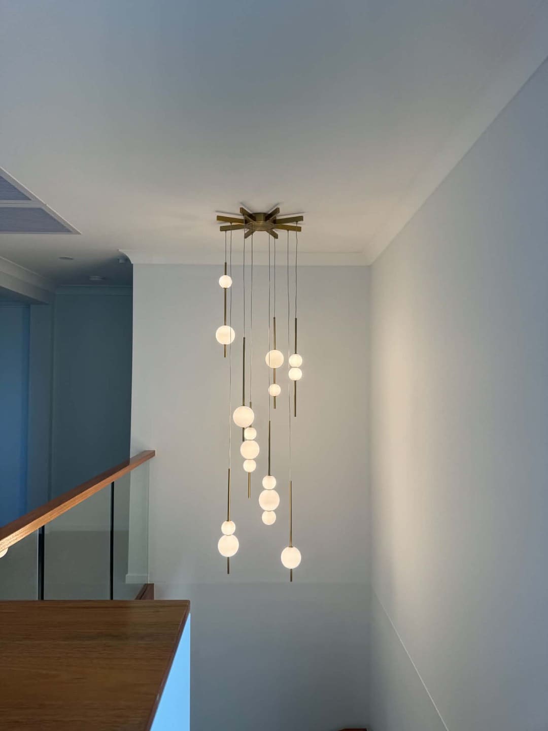 Custom multi-pendant staircase chandelier lighting installation by Total Blackout Electrical