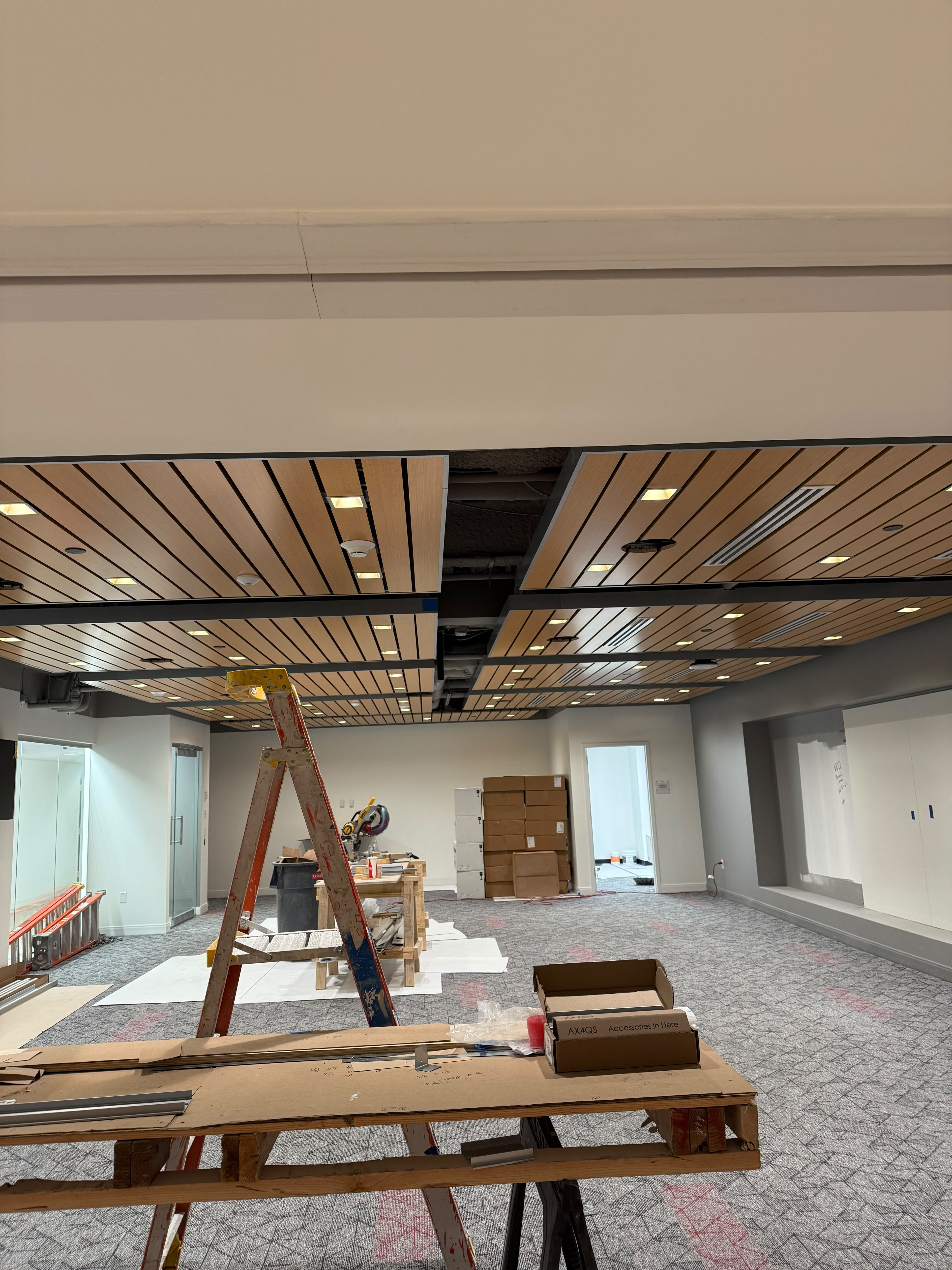 Suspended architectural wood slat acoustic ceiling panels with recessed lighting by LQJ General Construction in Hauppauge NY