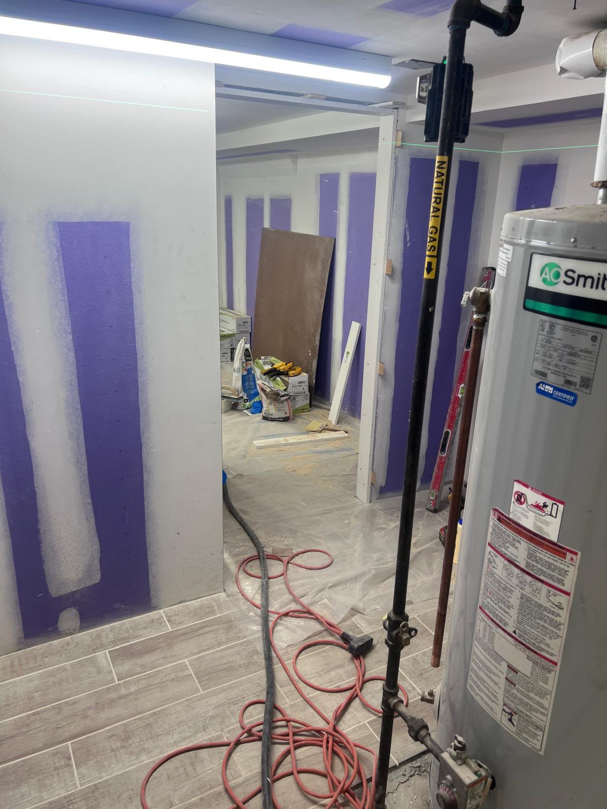 Basement drywall finishing with laser guide line and wood-look tile floor by LQJ General Construction in Bay Shore NY