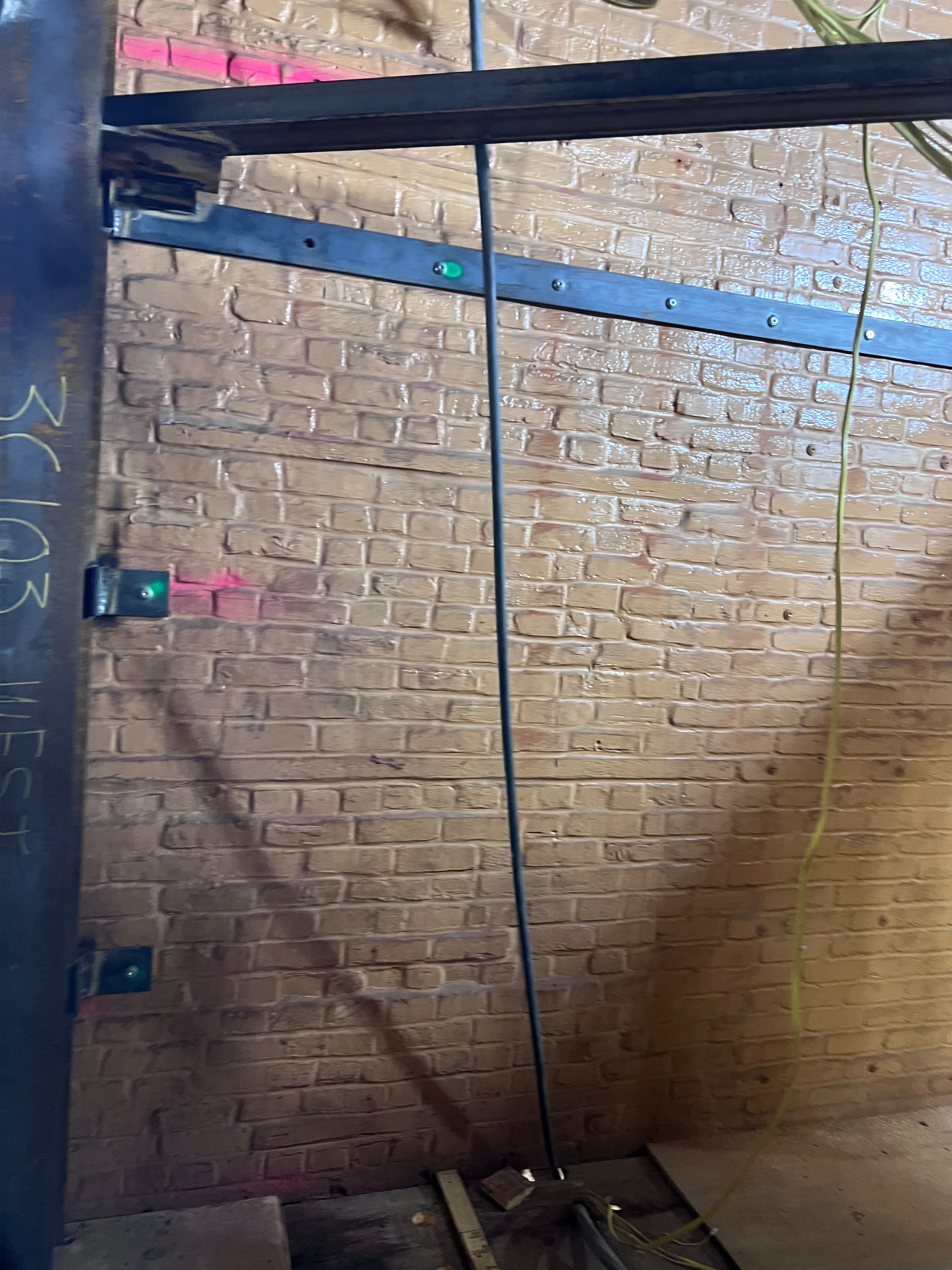 Close-up of structural steel support channel anchored to treated brick wall by LQJ General Construction in Central Islip NY
