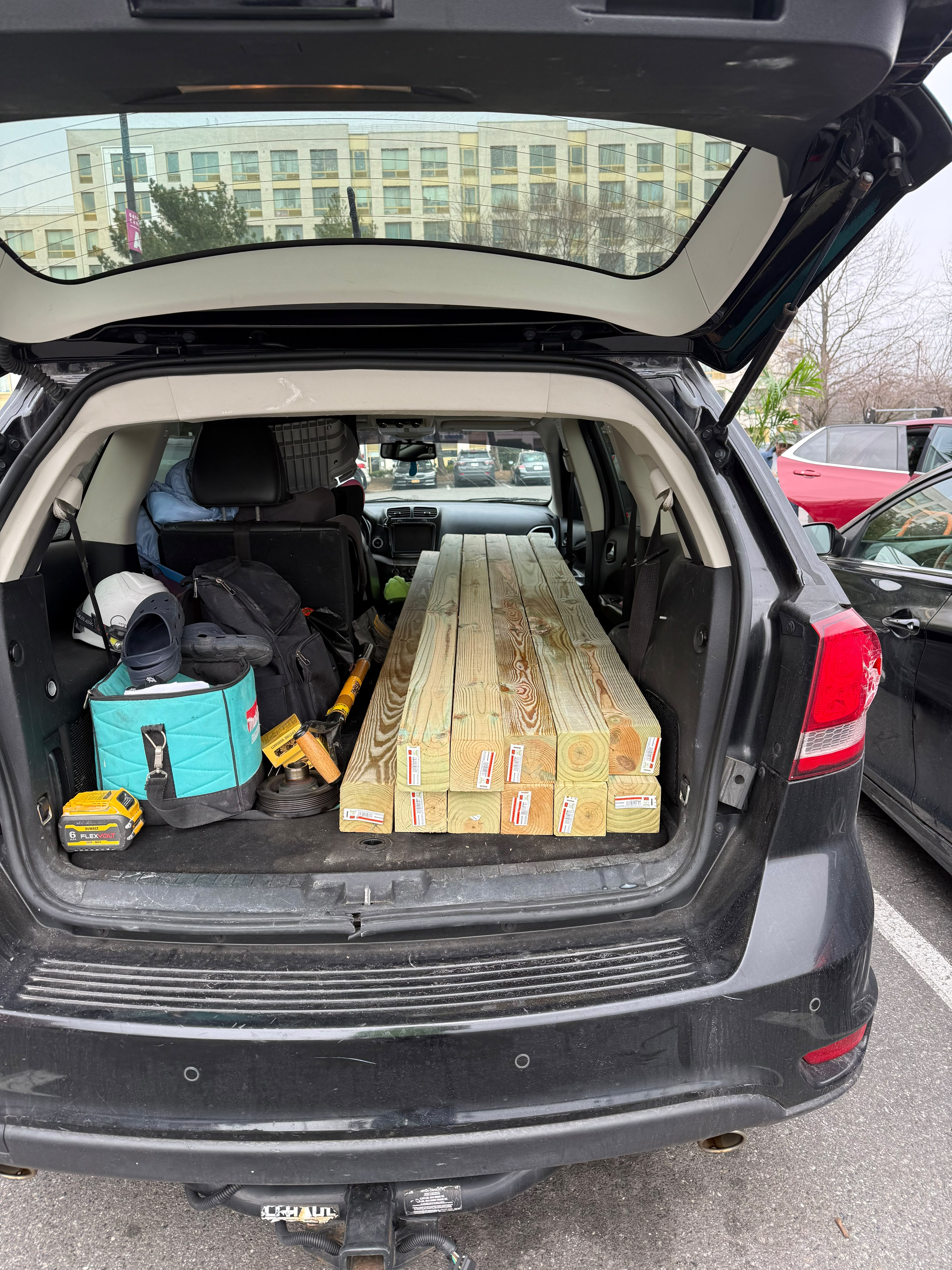 Commercial vehicle packed with pressure-treated structural timber posts and DeWalt power tools by LQJ General Construction in Central Islip NY