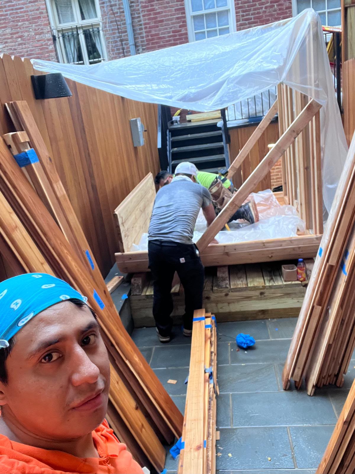 LQJ General Construction crew building custom outdoor cedar sauna with protective canopy in Northport NY