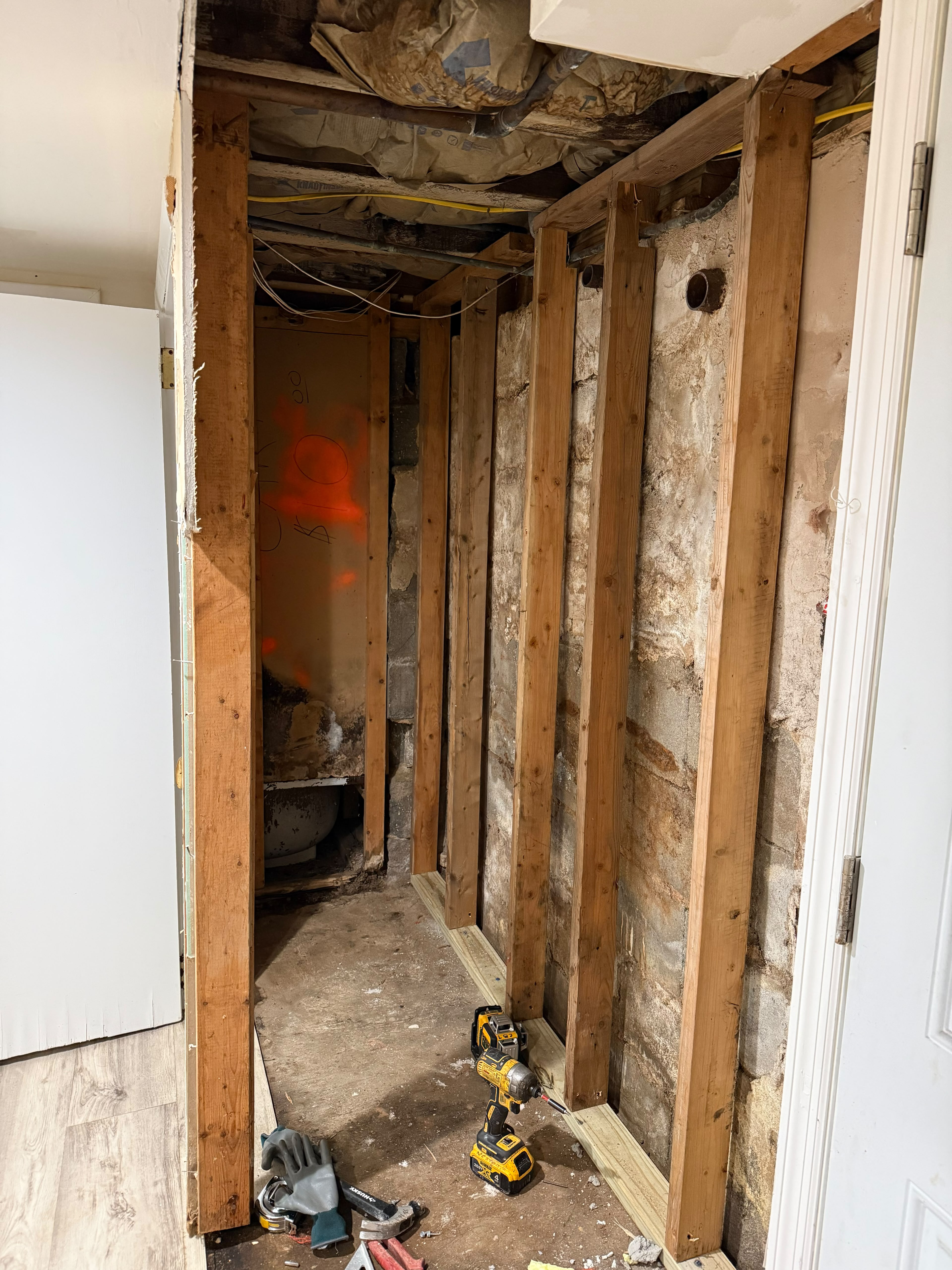 Basement perimeter wood stud wall framing and power drill installation by LQJ General Construction in Bay Shore NY