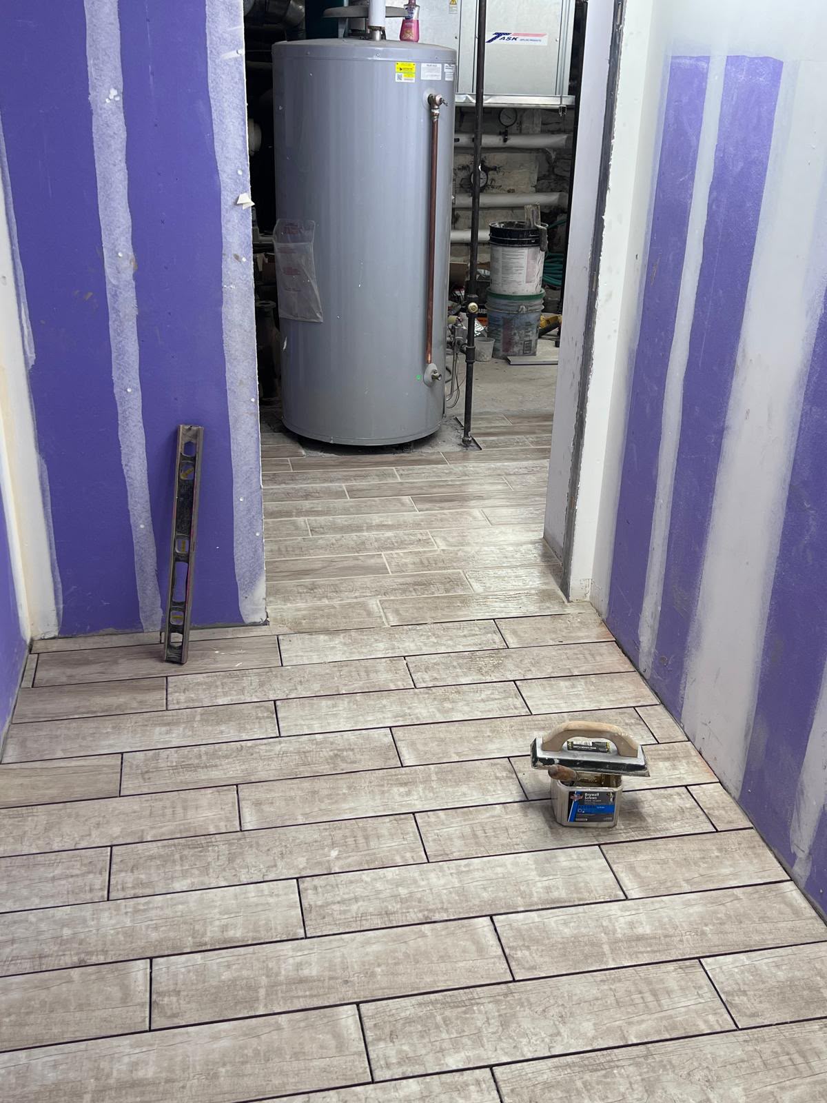 Finished wood plank porcelain tile floor and grout application in utility area by LQJ General Construction in East Northport NY