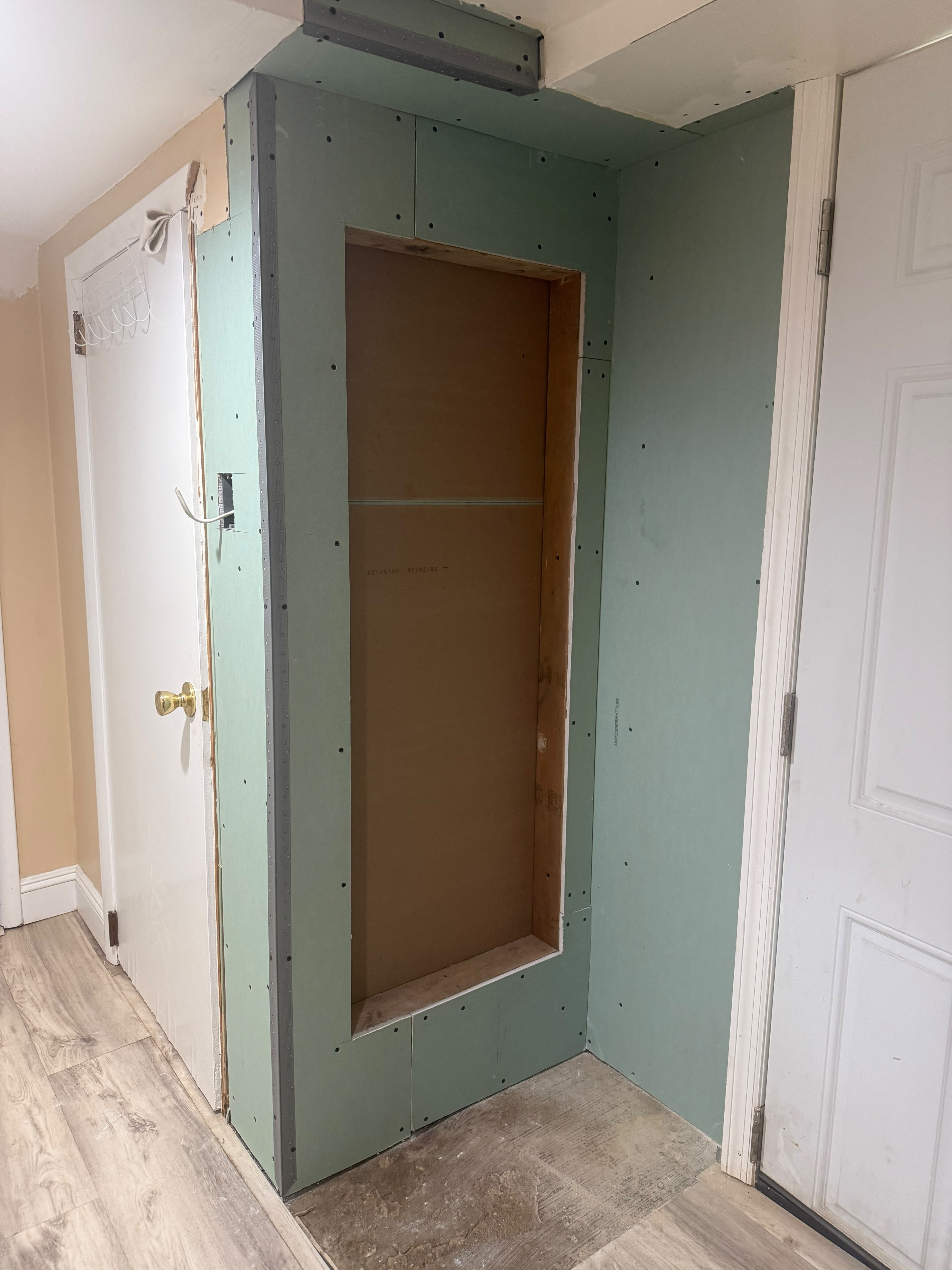 Metal corner beads and mold-resistant drywall installed on custom recessed built-in shelving niche by LQJ General Construction