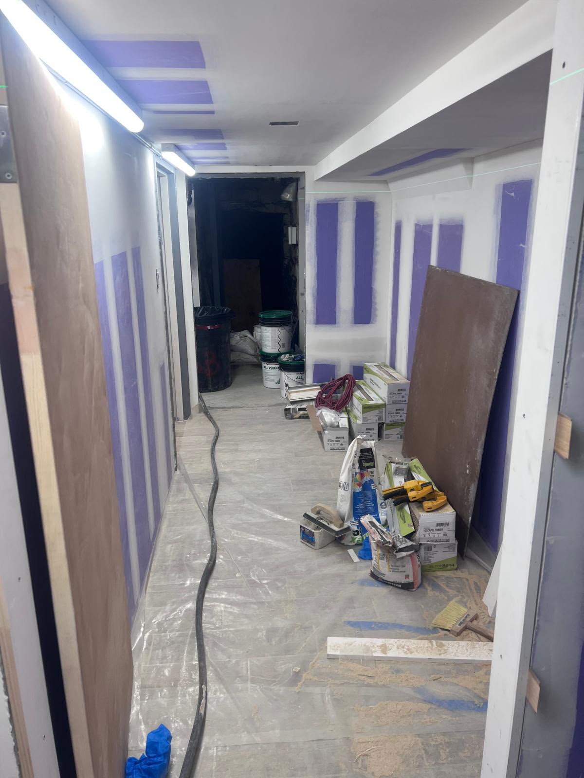 Basement hallway drywall mudding and green laser alignment line by LQJ General Construction in Bay Shore NY